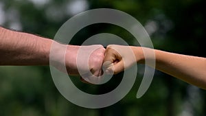 Man and child punching fists, parents as reliable support for children, closeup