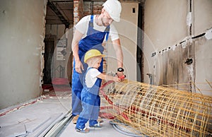 Man and child using building materials for home renovation.