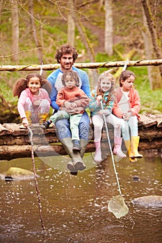 Man With Children On Bridge At Outdoor Activity Centre