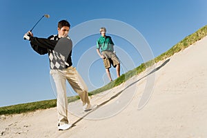 Man Chipping Golf Ball Out Of A Sand Trap