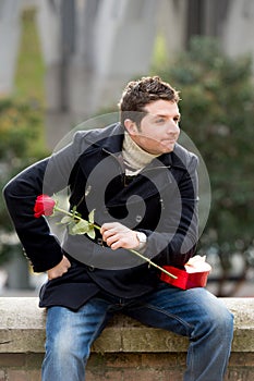 Man with chocolates and a rose being stood up photo