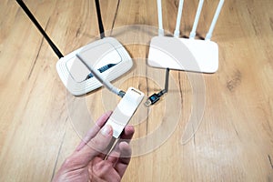 Man choose of different types of Wi-Fi routers, modern and old technology. Wireless ethernet connection signal. USB Wifi Receiver