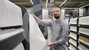 A man choose wallpaper in hardware store