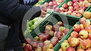 Man chooses apples in the supermarket