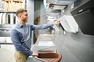 A man chooses a cooker hood in a store