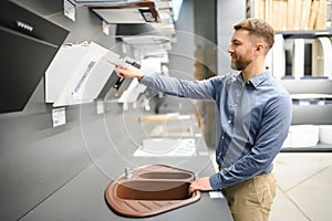 A man chooses a cooker hood in a store