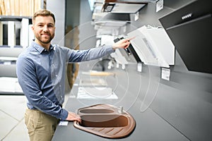 A man chooses a cooker hood in a store