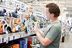 Man chooses electric saws in shop