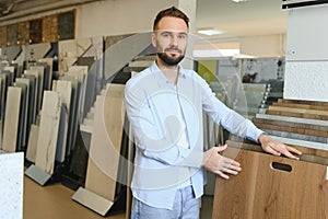 Man chooses floorboard laminate for home renovation in store