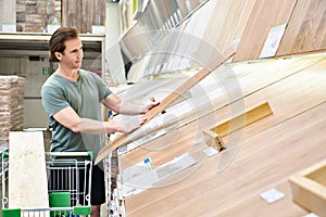 Man chooses floorboard laminate in store