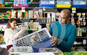 Man chooses a mammalian cage at pet store