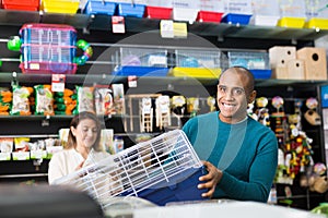 Man chooses a mammalian cage at pet store