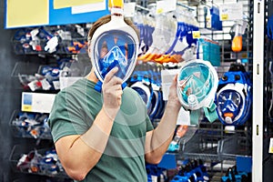 Man chooses mask for scuba diving in store