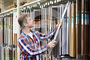 Man chooses metal plates for thresholds in a store