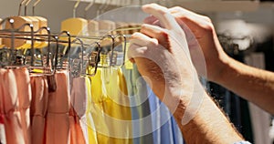 Man chooses purchase in women`s clothing store.