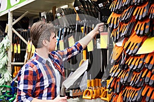 Man chooses shovel in shop