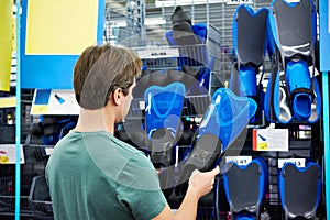 Man chooses swimfins for scuba diving in store