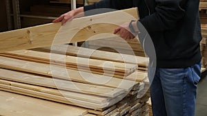 A man chooses wooden boards in a hardware store.