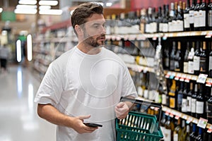 Man choosing alcohol bottles at liquor store. Man buying products at supermarket. Supermarket and grocery shop. Discount