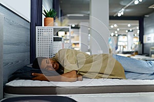 Man choosing bed checking orthopedic mattress softness