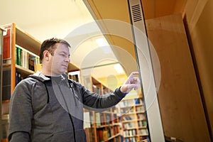 Man choosing book using touchscreen
