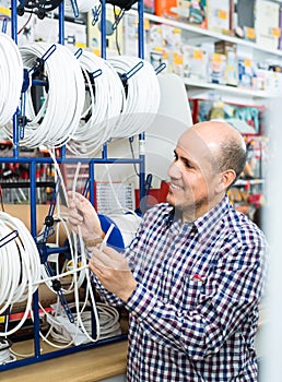 Man choosing cable in household store