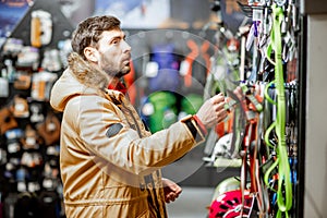 Man choosing choosing mountaineer equipment in the shop