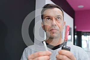 man choosing between e-cig and tobacco