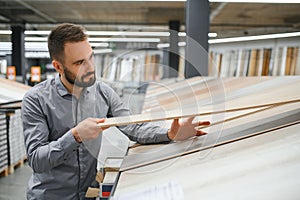 man choosing laminate samples in hardware store