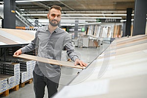 man choosing laminate samples in hardware store