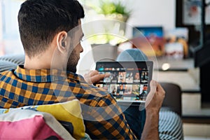 Man Choosing Movie For Streaming On Tablet Computer