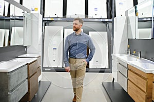 Man choosing new bathroom furniture at the plumbing shop with lots of sanitary goods