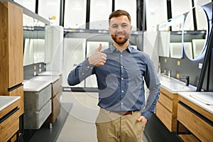 Man choosing new bathroom furniture at the plumbing shop with lots of sanitary goods