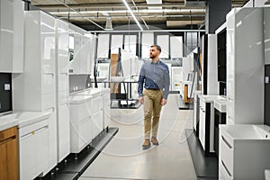 Man choosing new bathroom furniture at the plumbing shop with lots of sanitary goods