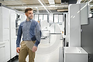 Man choosing new bathroom furniture at the plumbing shop with lots of sanitary goods