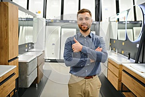 Man choosing new bathroom furniture at the plumbing shop with lots of sanitary goods