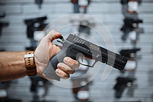 Man choosing new handgun in gun shop