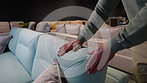 A man choosing sofa in furniture store, close up of hands