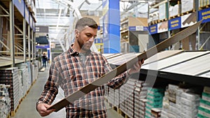 A man choosing wood laminated flooring in shop