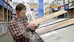 A man choosing wood laminated flooring in shop