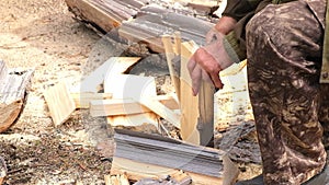 A man is chopping logs with an axe on chopping block. Harvesting of firewood stocks for heating.