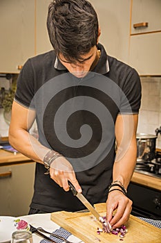 Man Chopping Red Onion with Sharp Knife in Kitchen