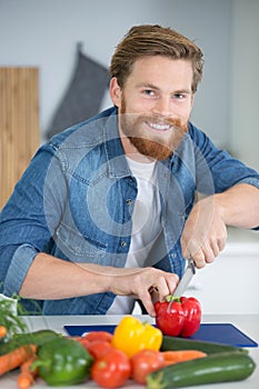 man chopping up red pepper