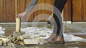 Man chopping wood in snow yard winter village