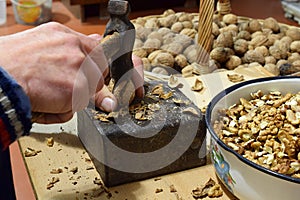 A man chops walnuts with a hammer