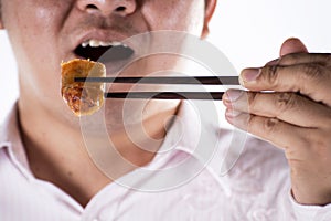 Man with chopsticks eat egg springroll