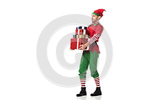 man in christmas elf costume carrying pile of presents isolated