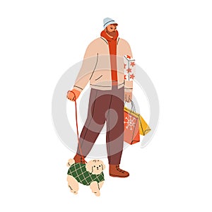 Man with Christmas gift boxes, shopping bags, walking with dog on leash on winter holiday. Happy person going on street