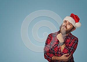 Man in Christmas hat looking up thinking