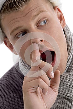 Man with christmas hat putting finger in his nose